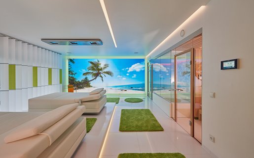 Two of the innovative SWAY pendulum loungers with ceiling-mounted sunlit meadow SONNENWIESE® lighting at a first-class wellness-area.