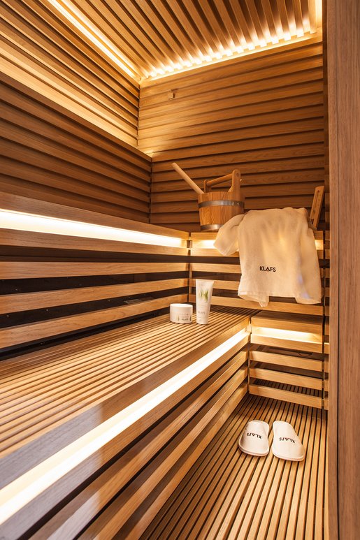 The uniquely striking face of this Matteo Thun sauna is characterized all around by the interplay of oak slats and joints. The heater is stowed under the bench to save space and is childproof.